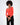 Model wearing a bright orange-red ribbed long sleeve off-the-shoulder top with black pants.