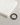 Braided brown bracelet with a black clasp beside neatly folded white clothing on a textured surface.
