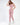 A model poses in a pink cut-out bodysuit and matching joggers, styled with white sneakers.