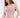 A model poses in a light pink bodysuit with cut-out sides, paired with matching pants.