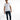 A man stands confidently in a fitted white t-shirt and distressed dark jeans, paired with white sneakers.