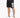 Black athletic shorts with a large white number graphic, paired with white sneakers and a casual fit.