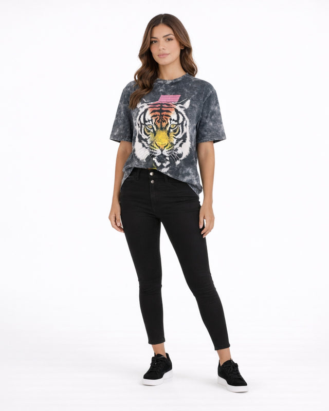 A woman stands confidently in a tie-dye graphic tee featuring a tiger design, paired with black skinny jeans and snea...