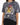 A model wearing a gray tie-dye t-shirt featuring a colorful tiger graphic and lightning bolt design.