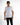 A model wearing a white short-sleeve shirt with the word "REVOLUTION" printed on the front, paired with black jeans.