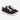 Black canvas sneakers with white laces and a textured finish, featuring a low-profile design and rubber sole.