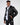 Man in Jerry Puffer Coat, a black insulated jacket with a fluffy collar, over a white hoodie and dark wash jeans.