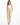 A woman walks confidently in beige high-waisted pants paired with a delicate white camisole and black heels.