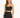 A model wearing a fitted black skirt with a high waist and a matching cropped top, showcasing a sleek silhouette.