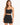 A model wearing a fitted black skirt with a high waist and a matching cropped top, showcasing a sleek silhouette.