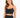 A woman with long hair wears a fitted black crop top with thin straps, showcasing a stylish and casual look.