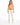 A woman stands confidently in light-colored, cropped pants paired with a fitted orange top and a braided brown belt.