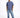 A man stands confidently wearing a blue oversized t-shirt and distressed light blue jeans with white sneakers.