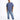 A man stands confidently wearing a blue oversized t-shirt and distressed light blue jeans with white sneakers.
