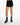 Black shorts with cut-out detailing and chain accents, paired with patterned high-top sneakers and black socks.