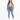 A woman stands confidently in light blue jeans paired with a cropped green top and a denim jacket.