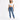 A woman stands confidently in a cropped white top and fitted blue jeans, paired with white sneakers.