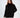 Model wearing a Celine black oversized knit turtleneck sweater with a unique distressed fringe hem against a white backdrop.