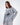 Model wearing an oversized light grey streetwear sweatshirt with a black circular nautical sailing ship graphic.
