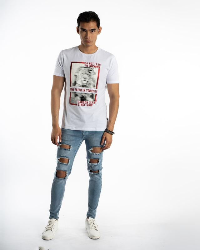 Model wearing Kase Blue Washed Denim Jeans with heavy knee distressing and a Carbon graphic t-shirt.