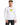 A man wearing a long-sleeve white shirt with a graphic print and black jeans, posing against a plain background.