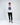 A young man stands confidently in a long-sleeve white shirt with a bold graphic and black cargo pants.