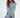 Model wearing the Saylor Blue Oversized Sweater, featuring a light blue distressed cable knit design.