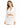 A model poses in a white cropped top with long sleeves and a matching mini skirt featuring cut-out details.