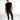 A man stands confidently in a fitted black t-shirt and olive cargo pants, paired with stylish sneakers.