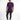 A model stands wearing a purple t-shirt with a graphic design, paired with dark jeans and black sneakers.