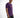 A man wearing a purple t-shirt with a graphic design, paired with dark jeans, poses against a light background.