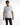 A model wearing a white short-sleeve shirt with colorful text and a graphic design on the front.