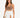 A woman poses in a fitted brown top and a flowing white skirt with high side slits, showcasing a stylish look.