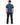 A man wearing a blue t-shirt and black pants stands with his back to the camera, showcasing a casual style.