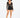 A model poses in a sheer long-sleeve top and high-waisted black shorts, showcasing a stylish, modern look.