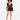 A model poses in a sheer long-sleeve top and high-waisted black shorts, showcasing a stylish, modern look.