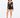 A model poses in a sheer long-sleeve top and high-waisted black shorts, paired with strappy heels.