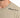 Close-up of a light beige t-shirt featuring black text that reads "LIVE AMPLIFY STYLE" on the shoulder.
