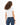 Back view of L.A. Vibes White Crop Top, a streetwear essential paired with dark blue jeans on a curly-haired model.