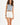 Woman in a blue-grey L.A. streetwear graphic tank top with raw hem and white high-waisted denim shorts.