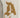 Beige apparel featuring a textured, brown logo design on the thigh, adding a unique visual element.