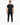 A man stands confidently in a fitted black t-shirt and slim black pants, paired with white sneakers.