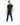 A man in a fitted black t-shirt and navy pants with a chain detail, walking in white sneakers.