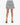 A short, pleated skirt with a black and white spotted pattern, paired with open-toed black heels.
