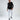 Model wearing a black long-sleeve graphic tee, ripped white skinny jeans, and black high-top sneakers.