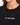 Close-up of a woman wearing a black tee featuring white embroidered text on the chest.