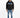 A man stands wearing a black hoodie with graphic text, paired with light blue jeans and stylish sneakers.