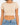 A fitted, short-sleeve top in a light beige color, paired with high-waisted blue denim jeans.