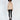Lilith beige ribbed knit sweater with shoulder cut-outs and black side stripes, paired with black skinny jeans.