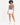 A model wearing a fitted bodysuit with a cutout design, paired with white shorts and sneakers.